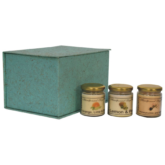Set of 3 scented candles, includes Orange, Lime & Basil, Lemon & Pine and Honeysuckle & Jasmine. set in front of a gift box on a white background